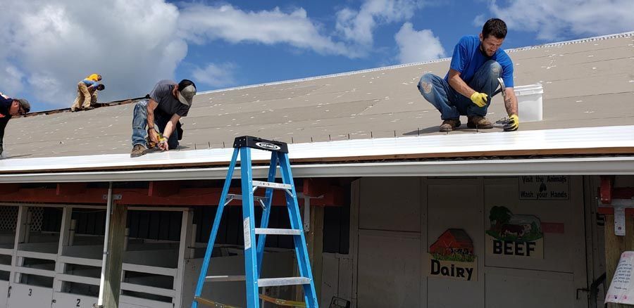A group of men are working on the roof of a building.