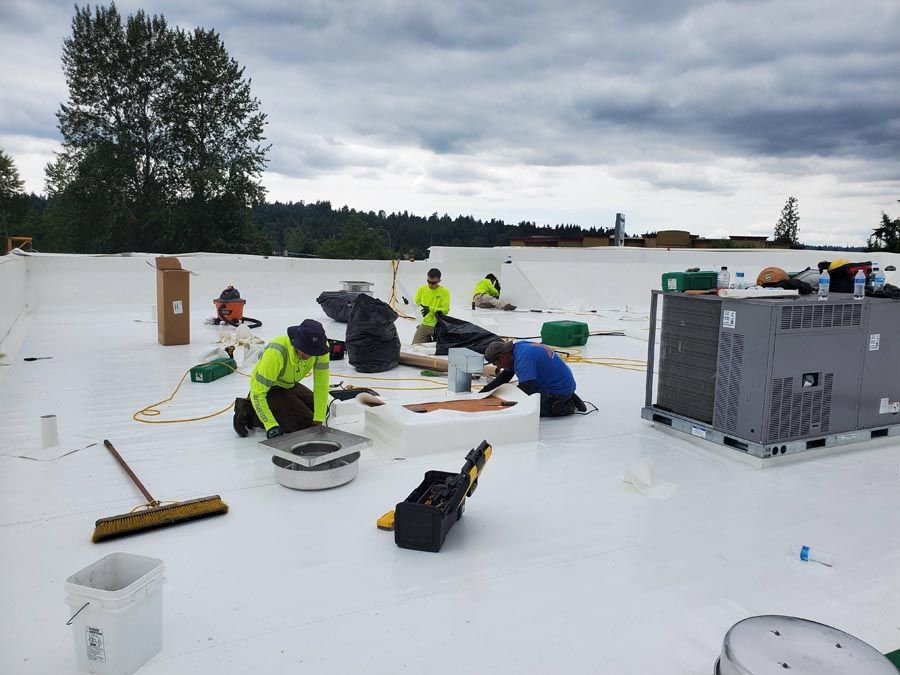 A group of people are working on a white roof.